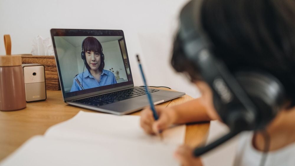 Asian boy doing homework at home. The school has been closed during coronavirus outbreak and the classes have moved to e-learning platform.