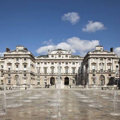the courtauld building with fountains in front against a blue sky