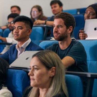 Students in a lecture theatre, with laptops in front of them.