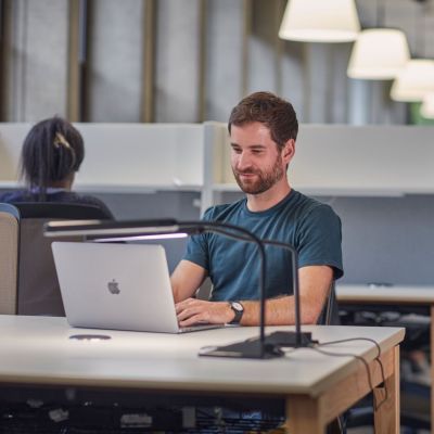 Male student working at a laptop, in a quiet study space.