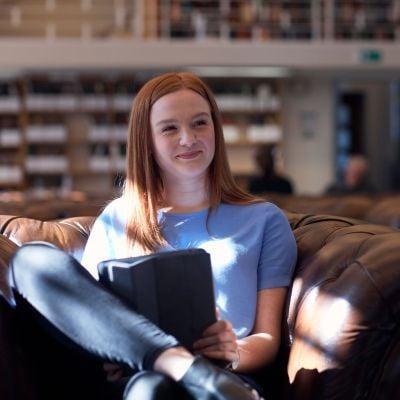 Female student studying in a library.