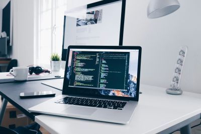 Laptop on a desk with coding on the screen