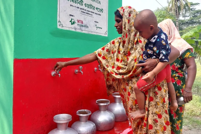A woman and her baby getting clean water. 