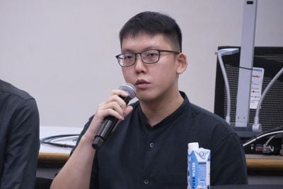 Koh Jian Xiang speaking into a microphone