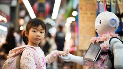 A young girl interacts with a robot