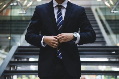 Man in a suit walking down some stairs in an office