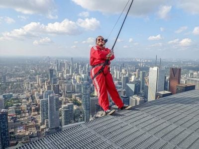 Hussain on the end of the CN tower hung on by a rope