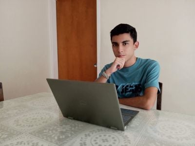 Sebastián sitting at a desk behind a laptop