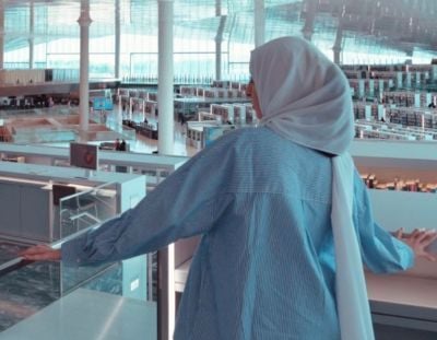 Tehmina looking out over a glass balcony to her place of study