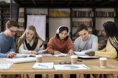 5 students around a desk studying