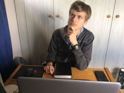 Ricco at his desk looking puzzled into the distance