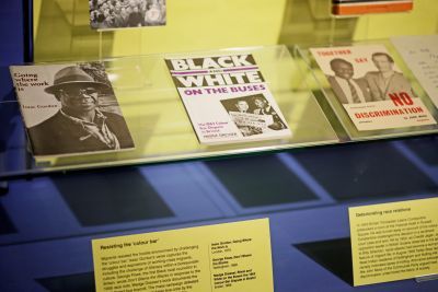 A display case containing three pamphlets - Going Where the Work is by Isaac Gordon, Black and White on the Buses by Madge Dresser and Together Say No Discrimination by John Moss