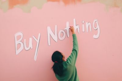 Woman drawing words buy nothing on a wall