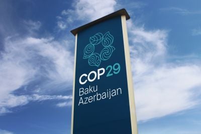 A sign with the words 'COP29 Baku Azerbaijan' against a blue sky with pale clouds.
