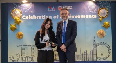 Yap Lin Suen accepts a prize from Professor Phil Allmendinger at SIM-UoL Achievers Event 2024