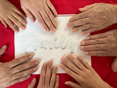 Hands around a page with the word family written on 
