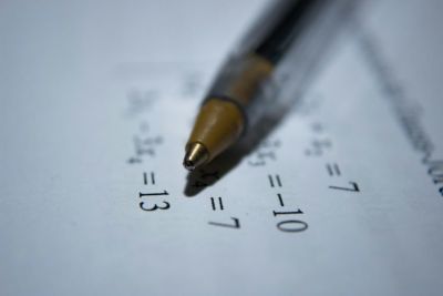 Picture of a pen on a piece of paper with algebra on 