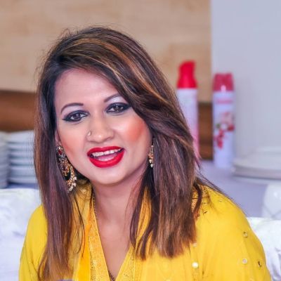 Farhana Rahman smiling wearing a yellow blouse.