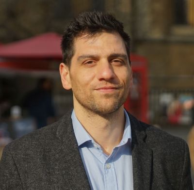 A headshot of a dark haired white man