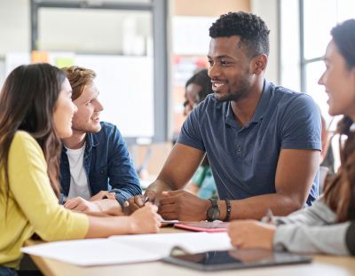 AI generated image:  Students smiling around a table.