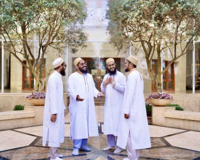 Four men in religious dress smiling and chatting together.