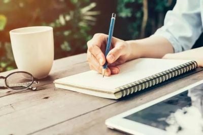 Student making notes in pencil on a notepad