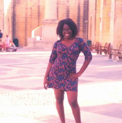 Student posing for a picture inside a cathedral style building